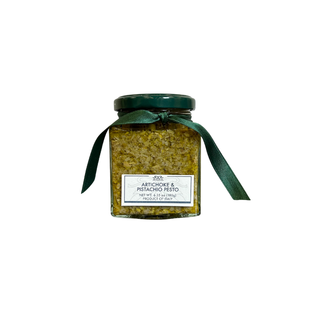 Jar of artichoke pesto with a green ribbon on a white background